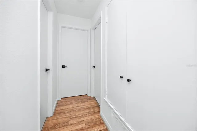 a view of a hallway with wooden floor