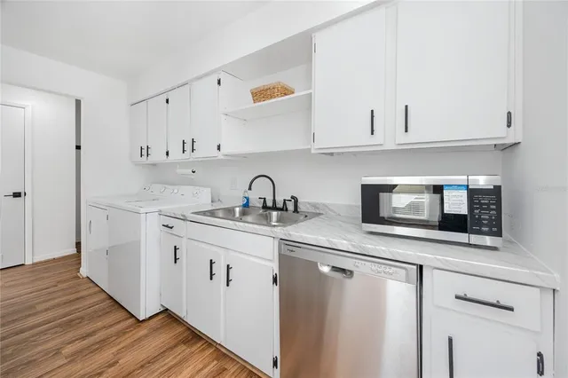 a kitchen with granite countertop white cabinets and white appliances