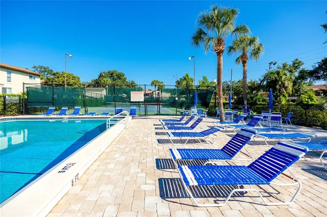 a view of swimming pool with chairs and tables