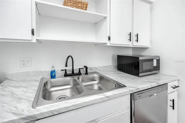 a kitchen with granite countertop white cabinets and a sink