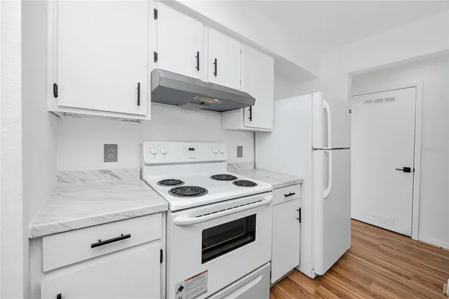 a kitchen with stainless steel appliances granite countertop a stove and a refrigerator