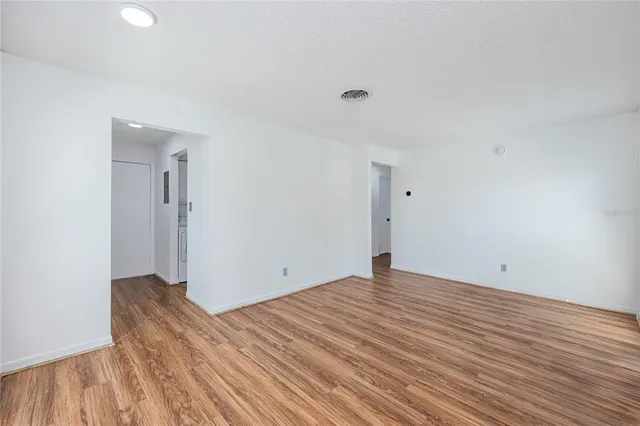 a view of an empty room with wooden floor