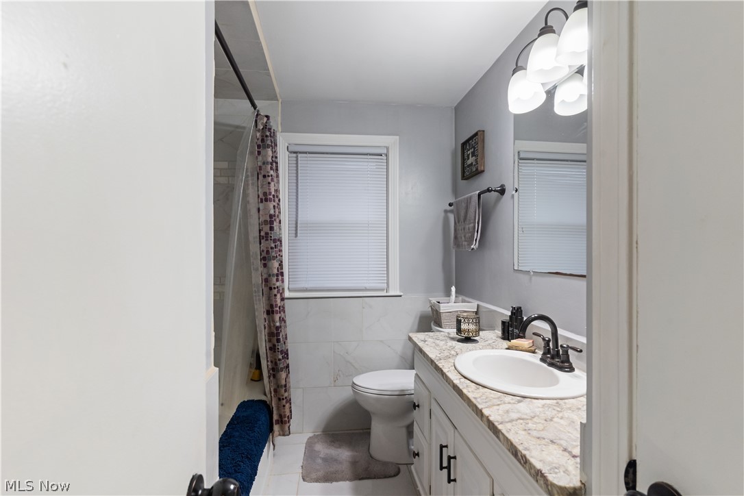3701 Shields Road Canfield, OH 44406 - Photo 12 of 15 Bathroom featuring vanity, tile walls, and light tile patterned flooring