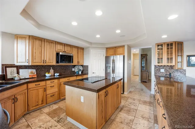 a kitchen with stainless steel appliances granite countertop a table chairs and a dining table view