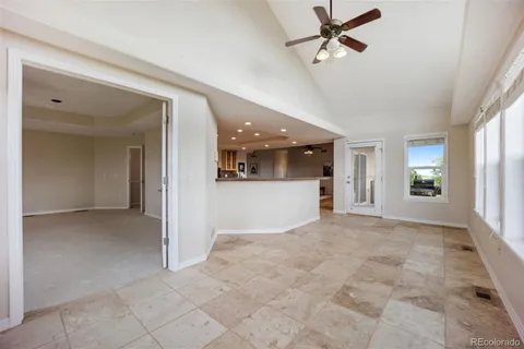 a view of a big room with windows and ceiling fan
