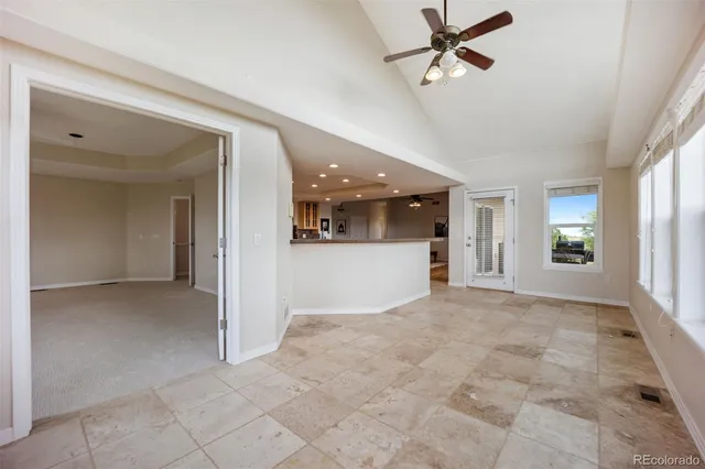 a large kitchen with kitchen island a large window a sink stainless steel appliances and cabinets