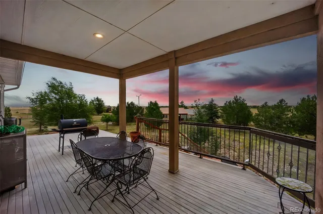 a view of a chairs and table in patio with a wooden fence