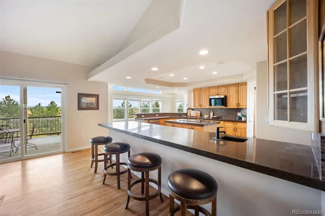 a kitchen with stainless steel appliances granite countertop a table chairs and a dining table view