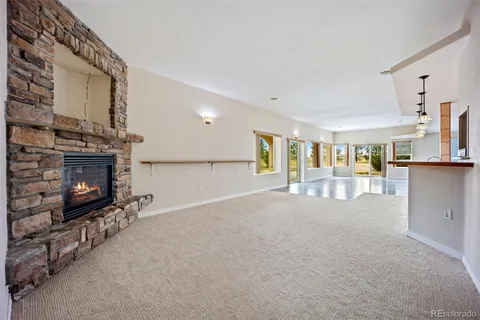 a view of an empty room with fireplace and a window