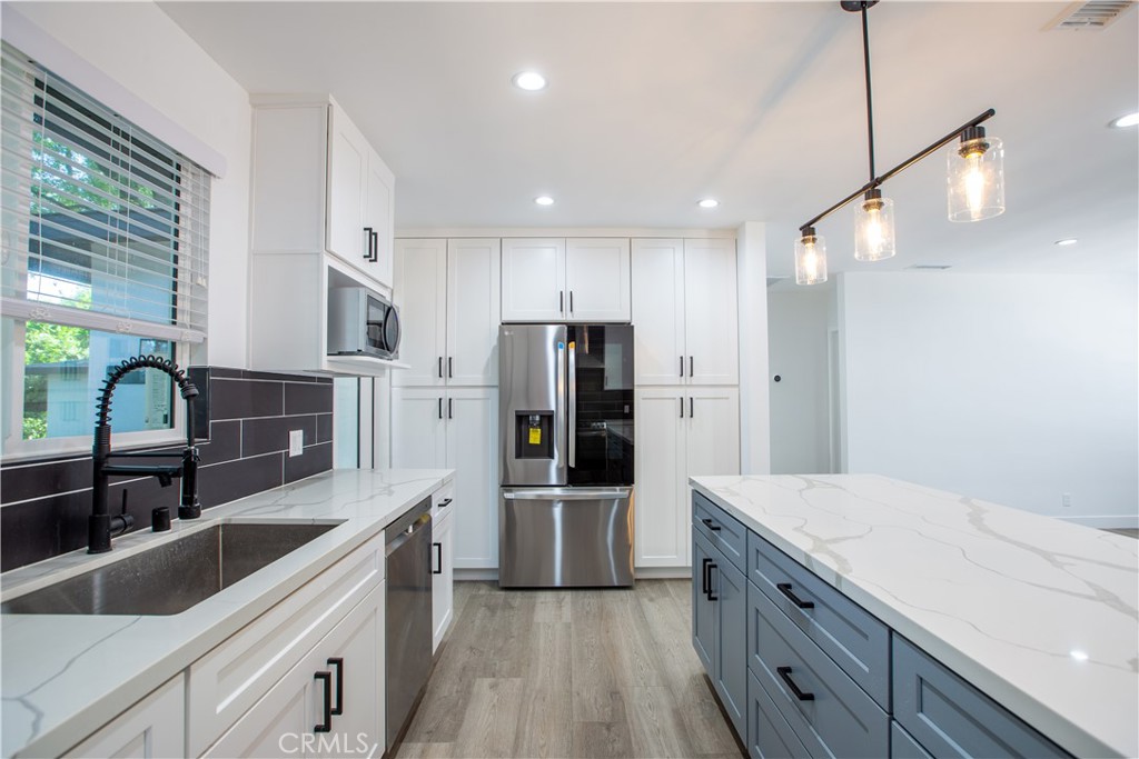 19503 Cantara Street Reseda, CA 91335 - Photo 1 of 19 a kitchen with granite countertop a refrigerator and a sink