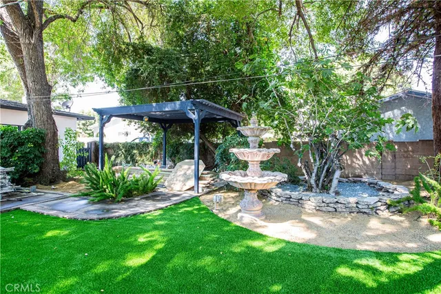 a view of a chair and table in backyard of the house