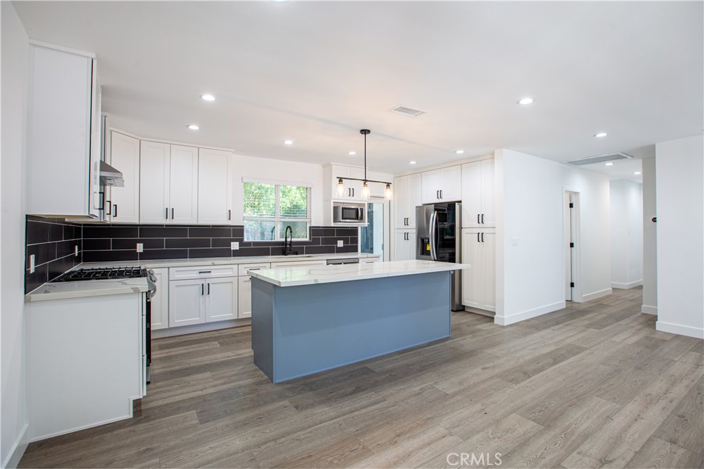 19503 Cantara Street Reseda, CA 91335 - Photo 4 of 19 a kitchen with stainless steel appliances granite countertop a stove a sink and a refrigerator
