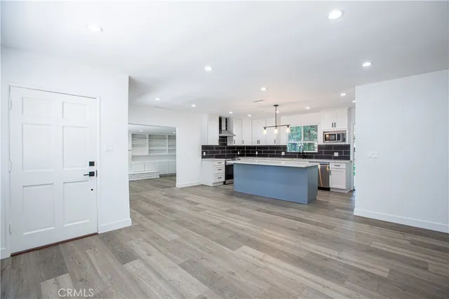 a large kitchen with stainless steel appliances granite countertop a stove and a refrigerator