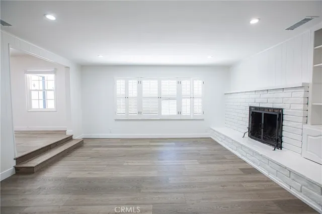 an empty room with wooden floor and fireplace