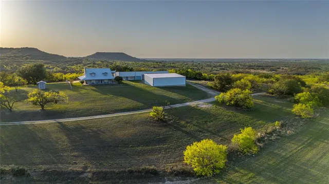 a bedroom with a bed a desk and chair with window