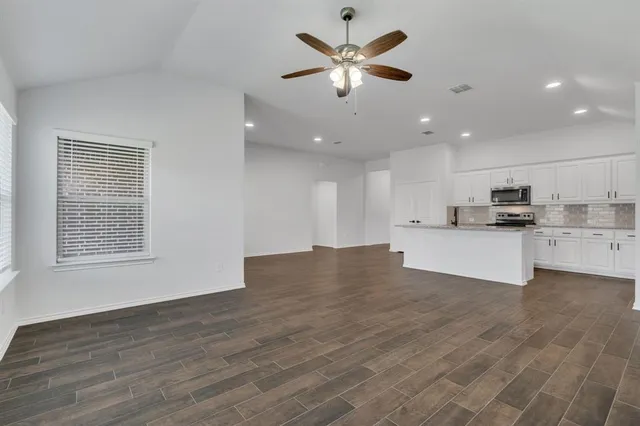an empty room with wooden floor and window