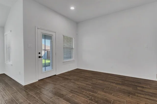 wooden floor in an empty room with a window