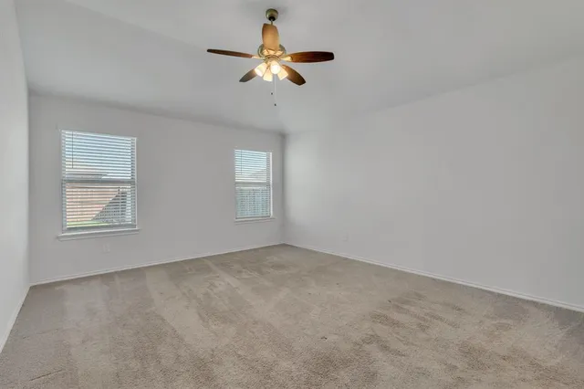 an empty room with a window and a ceiling fan