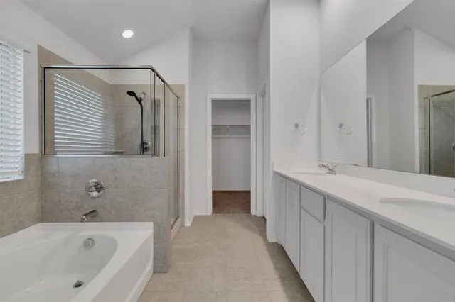 a bathroom with a tub sink and mirror
