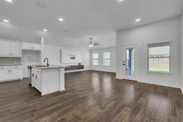 a view of kitchen with stove refrigerator and cabinets