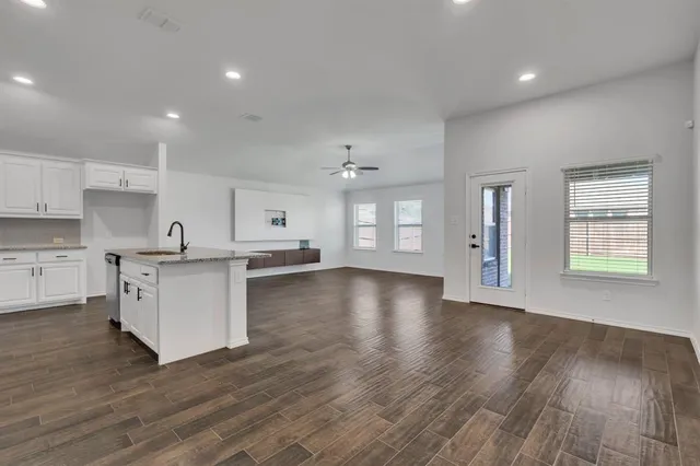 a view of kitchen with stove refrigerator and cabinets