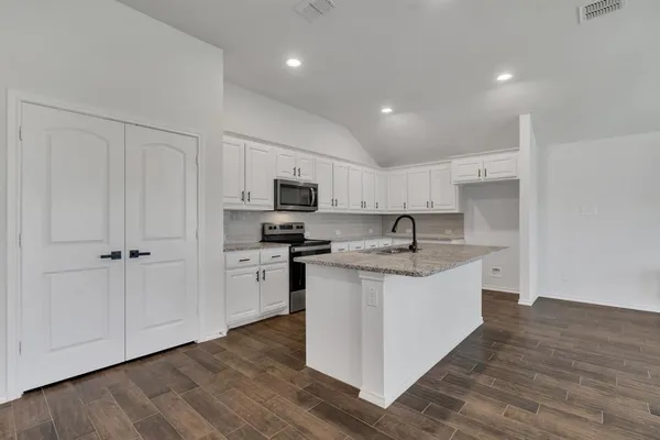 a large kitchen with stainless steel appliances granite countertop a sink and cabinets