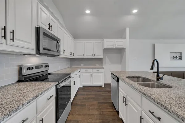 a kitchen with granite countertop a sink and stainless steel appliances