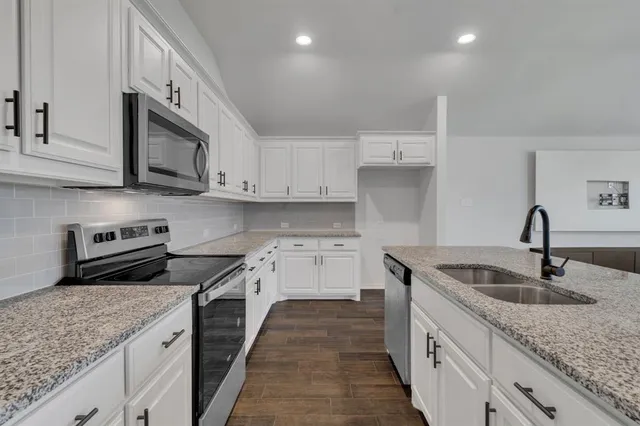 a kitchen with granite countertop a sink and stainless steel appliances