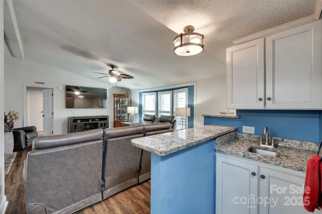 a kitchen with granite countertop a sink stainless steel appliances and cabinets