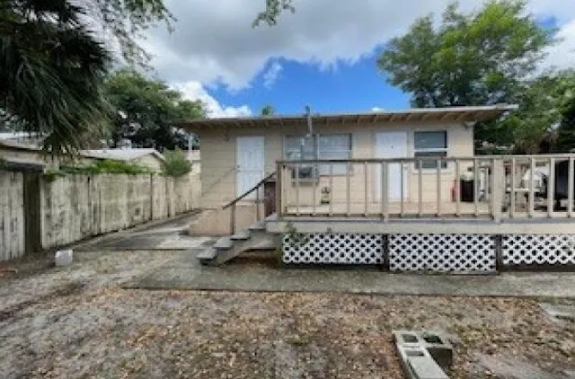 a white house that has tree in front of it