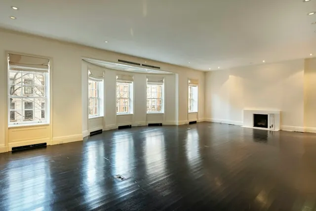 a view of an empty room with furniture and a fireplace