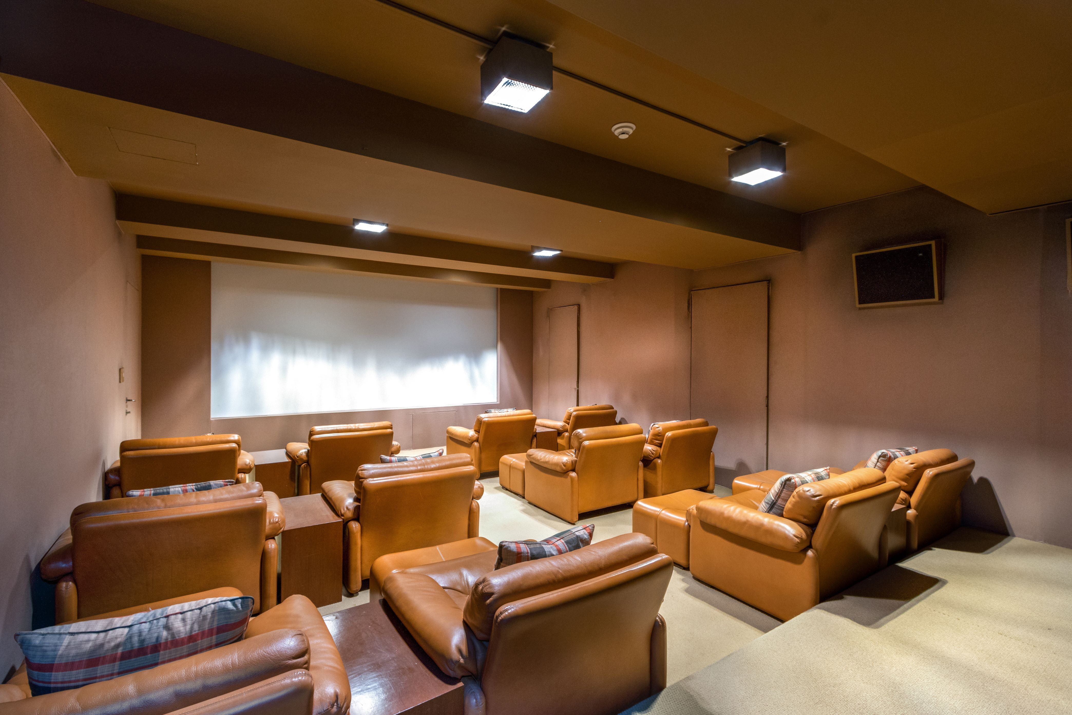36 East 63rd Street Manhattan, NY 10065 - Photo 19 of 21 a media room with lots of chairs and a projector screen