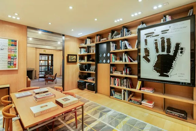 a living room with furniture a rug and a book shelf