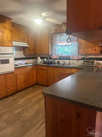 a kitchen with stainless steel appliances a sink window and cabinets