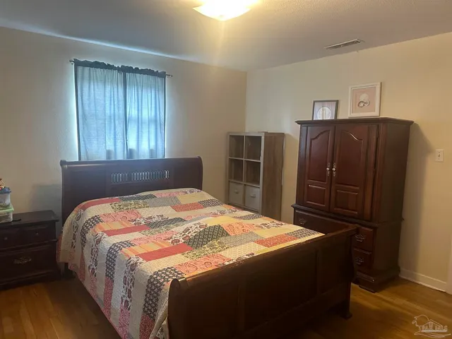 a bed sitting in a bedroom next to a window