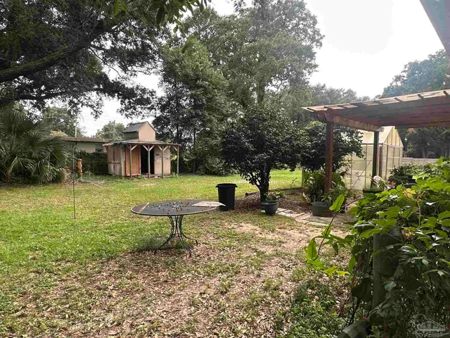 a view of a house with backyard and sitting area