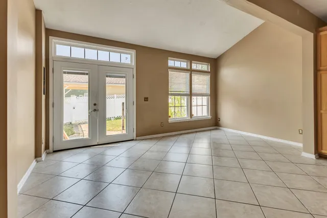 a view of an empty room with window and chandelier