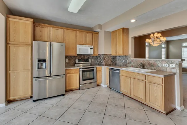 a kitchen with a refrigerator sink and cabinets