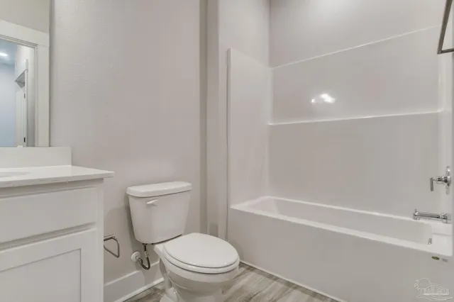 a white toilet sitting next to a bath tub