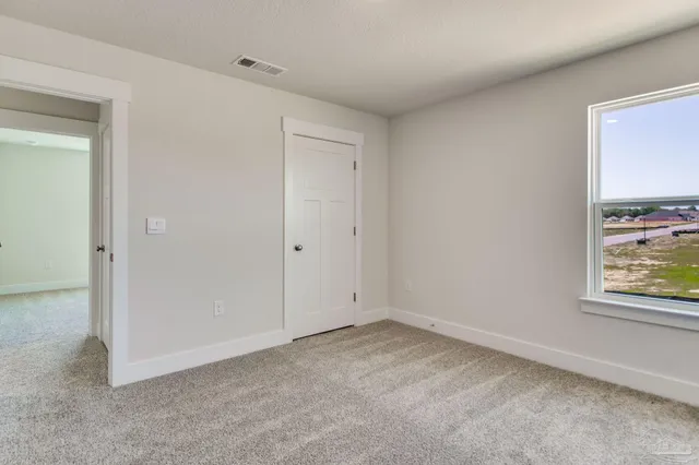 an empty room with windows and closet