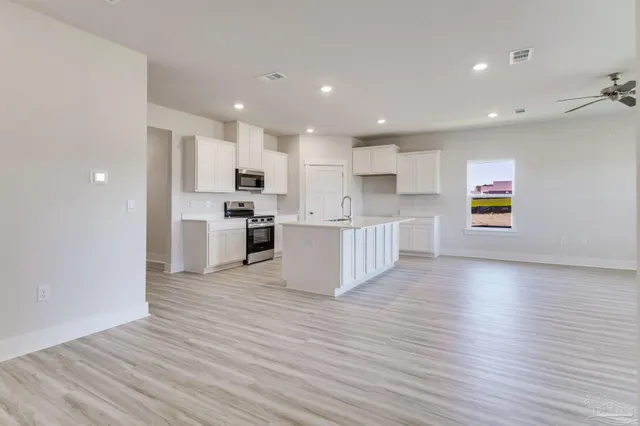 a view of kitchen view wooden floor stainless steel appliances and cabinets