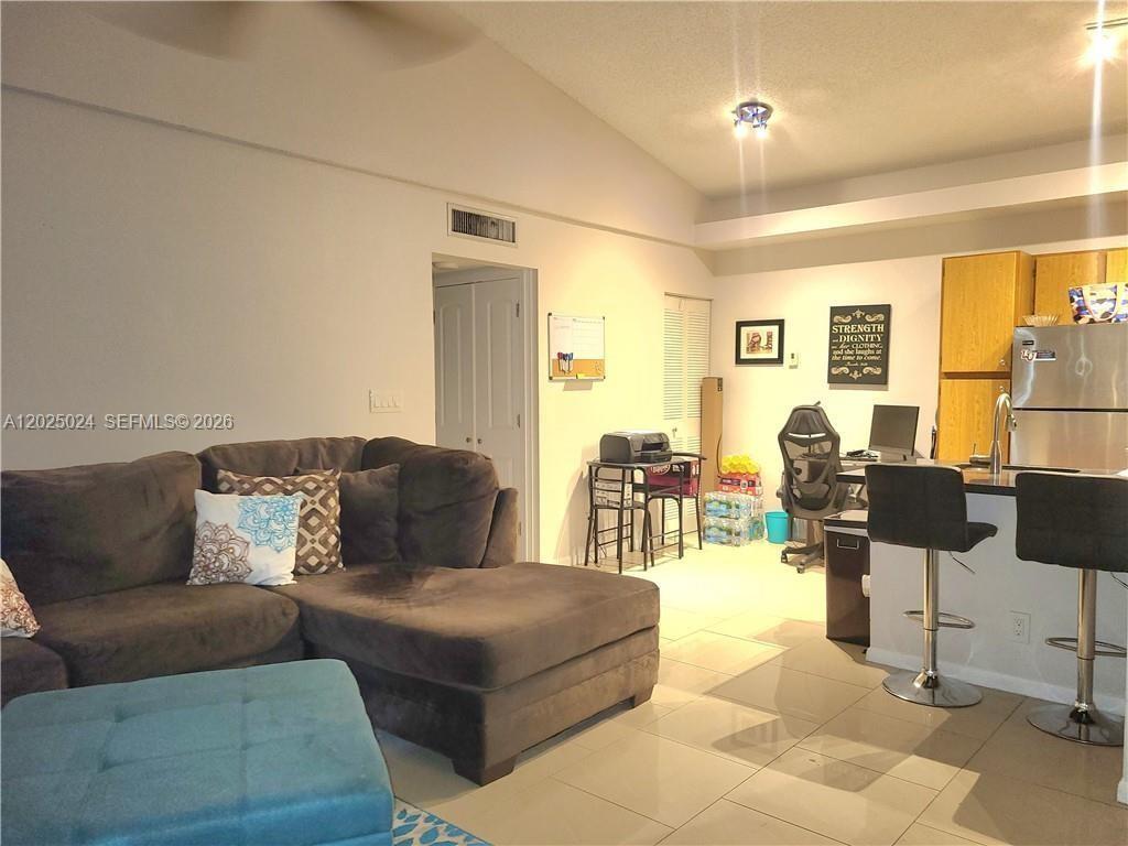 631 Lyons Road, Unit 12205 Coconut Creek, FL 33063 - Photo 3 of 14 a living room with furniture and a large window