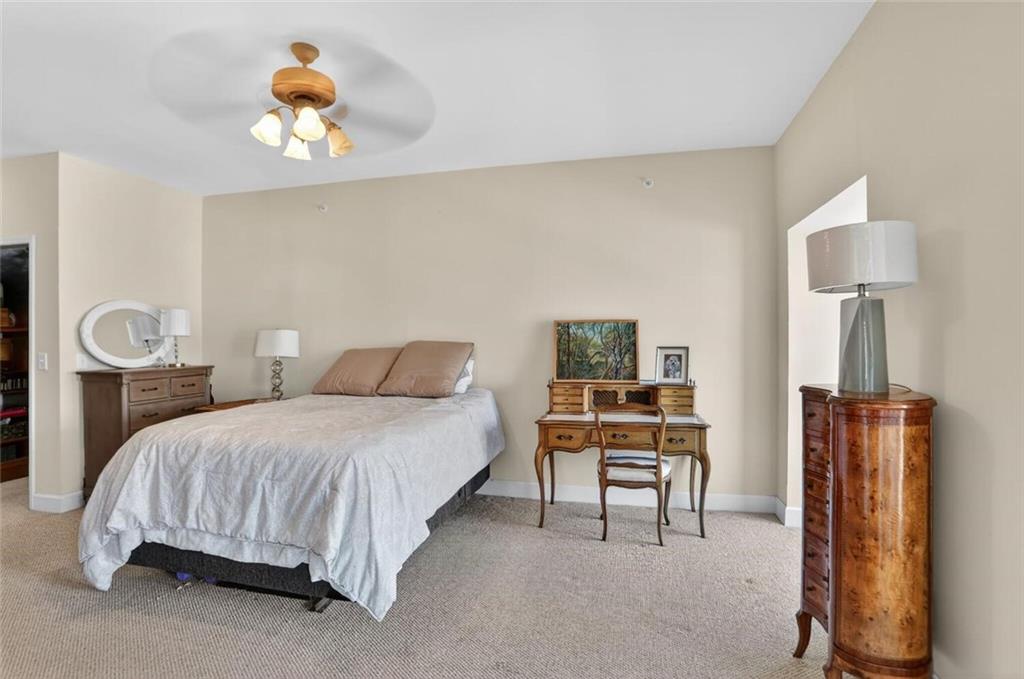 2921 Lenox Road Northeast, Unit 413 Atlanta, GA 30324 - Photo 15 of 36 a bedroom with a bed and a chandelier