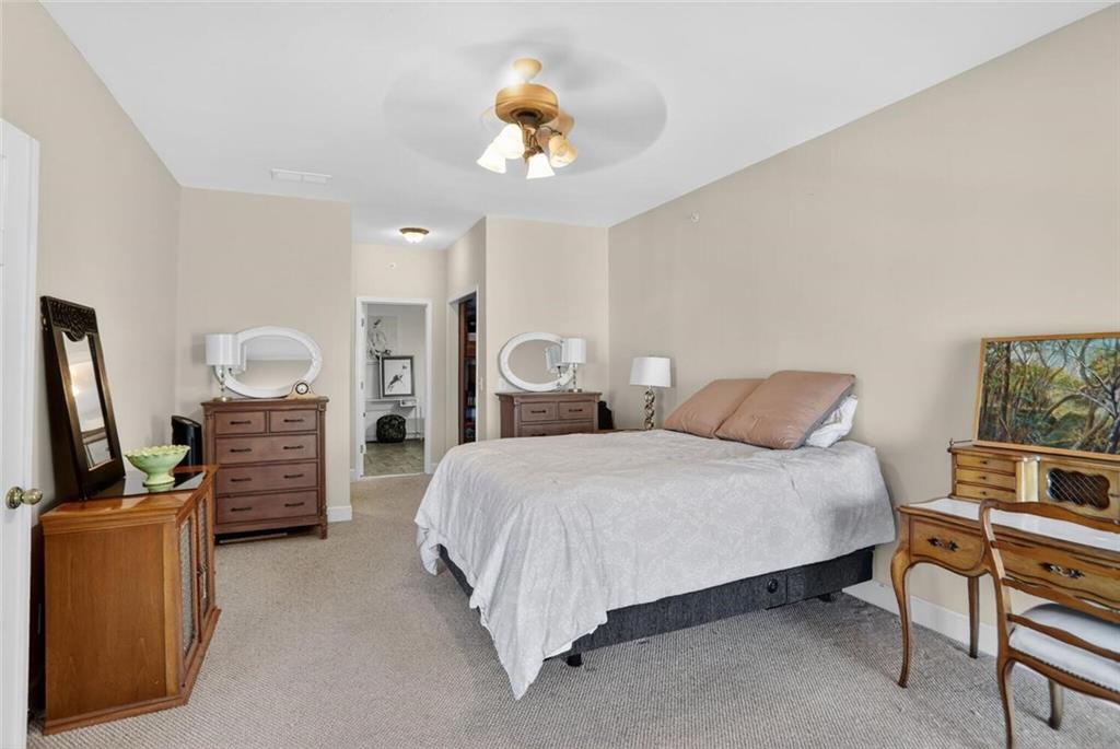 2921 Lenox Road Northeast, Unit 413 Atlanta, GA 30324 - Photo 16 of 36 a bedroom with a bed and a chandelier
