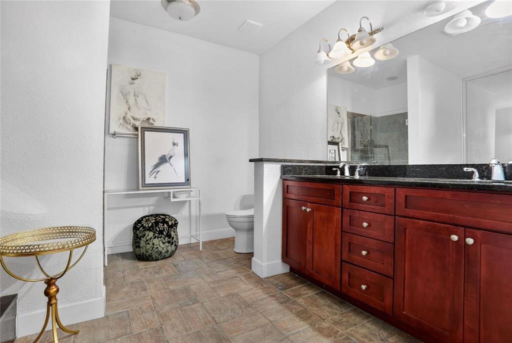 2921 Lenox Road Northeast, Unit 413 Atlanta, GA 30324 - Photo 19 of 36 a spacious bathroom with a granite countertop sink a mirror and shower