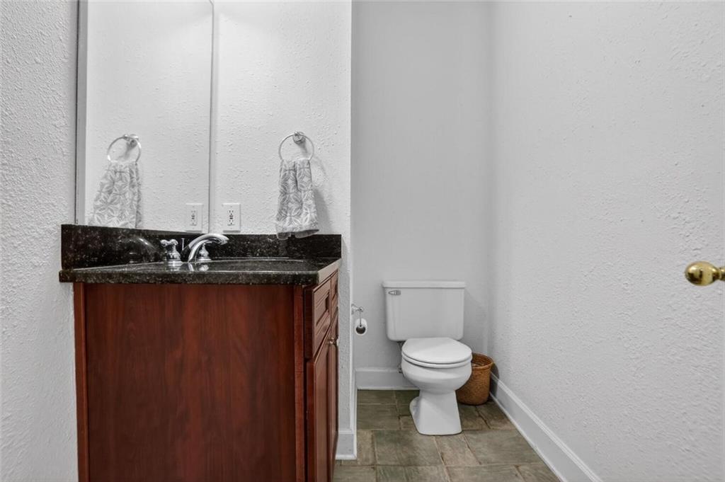 2921 Lenox Road Northeast, Unit 413 Atlanta, GA 30324 - Photo 23 of 36 a bathroom with a granite countertop sink and a toilet