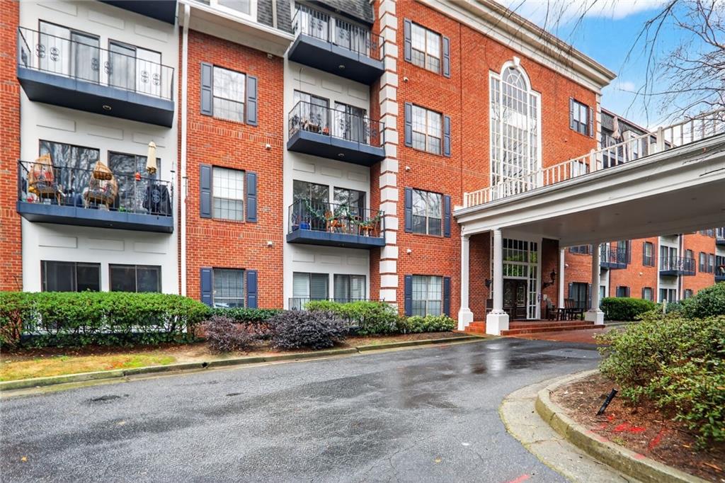 2921 Lenox Road Northeast, Unit 413 Atlanta, GA 30324 - Photo 27 of 36 a front view of a brick building with a yard