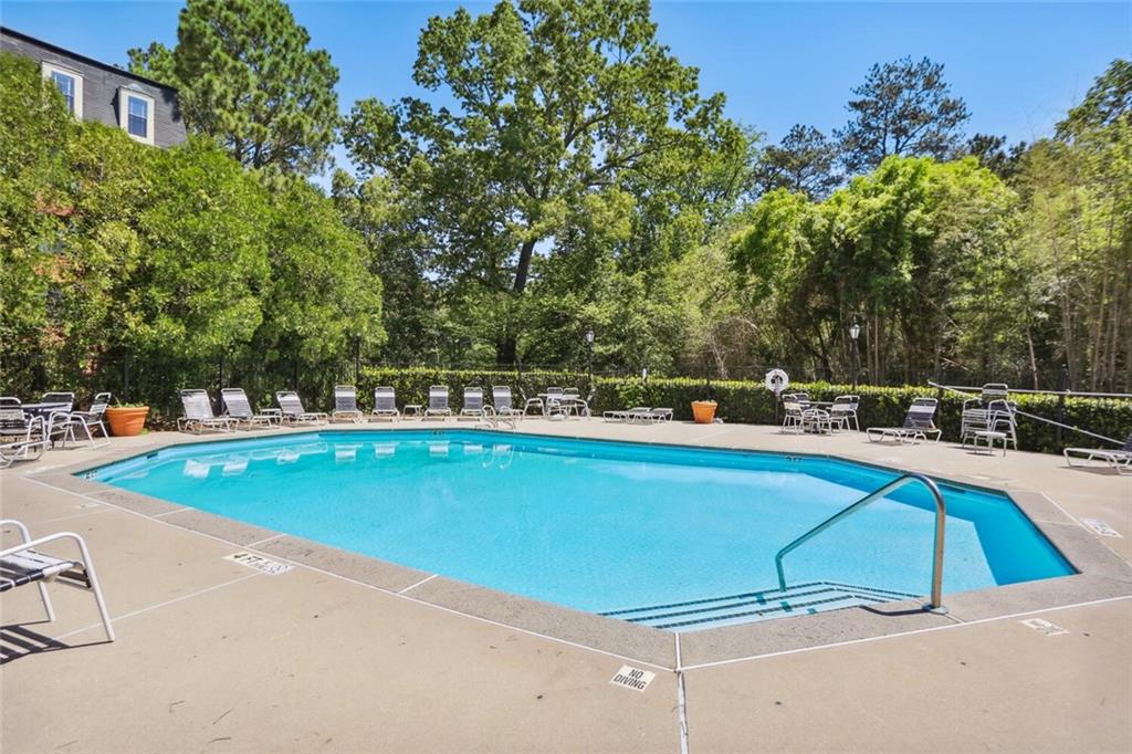 2921 Lenox Road Northeast, Unit 413 Atlanta, GA 30324 - Photo 28 of 36 a view of a swimming pool with an outdoor seating and a yard