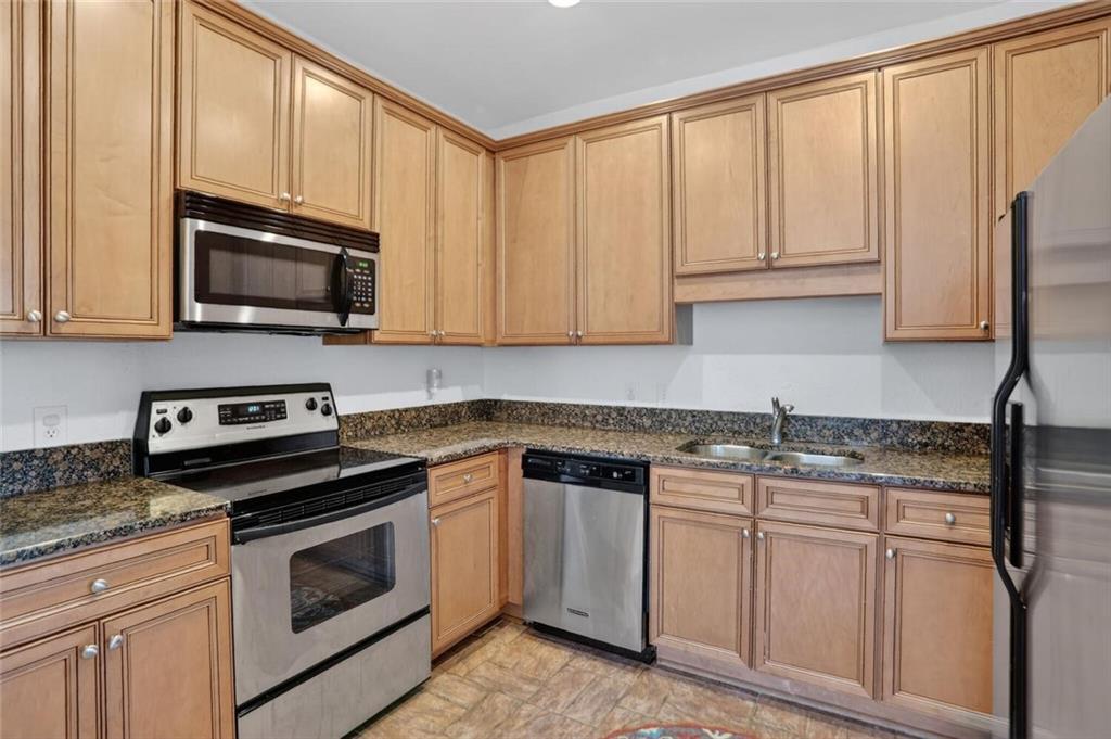 2921 Lenox Road Northeast, Unit 413 Atlanta, GA 30324 - Photo 9 of 36 a kitchen with granite countertop cabinets stainless steel appliances and a sink