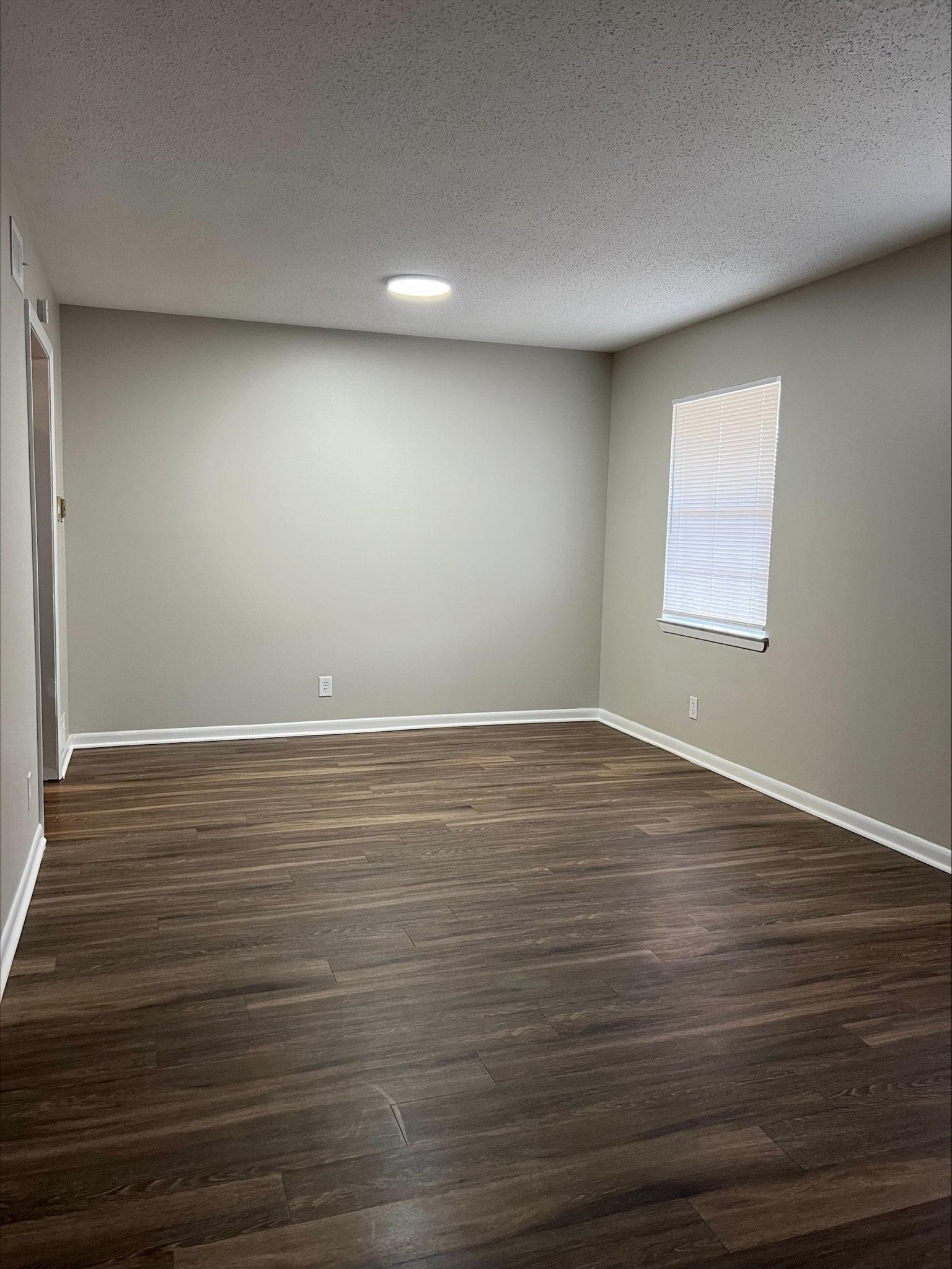 3831 Millbranch Road Memphis, TN 38116 - Photo 4 of 12 wooden floor in an empty room with a window